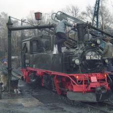 Nach erfolgter Hauptuntersuchung sollte sich 99 1542-2 am 7.April 1993 auf einer Lastprobefahrt von Cranzahl nach Oberwiesenthal bewähren. Am Wasserkran und Kohlebansen wird die Lok in Cranzahl auf ihre Premierenfahrt im Eigentum der IG Preßnitztalbahn e.V. vorbereitet.