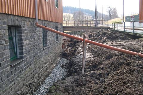 Nachdem der Schlamm vom Fundament entfernt wurde, wird nun eine mehrschichtige Abdeckung und Drainage eingebaut.