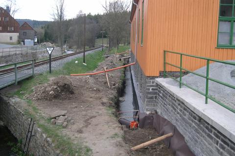 Der vorgefüllte Beton am Fundament auf der Gleisseite wird mit Folie geschützt.