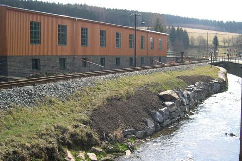 Ein Jahr nach dem Hochwasserschaden bleibt nur noch eine Stein-Narbe an der Uferböschung.