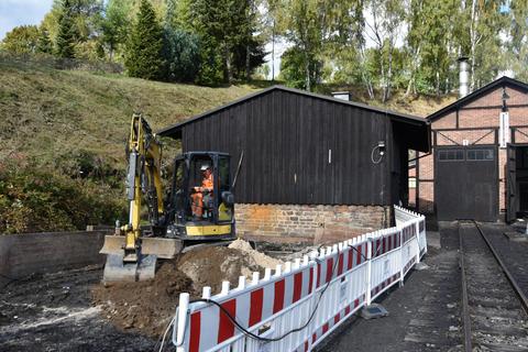 Mit einem Kleinbagger wird der Graben am Hang ausgehoben.