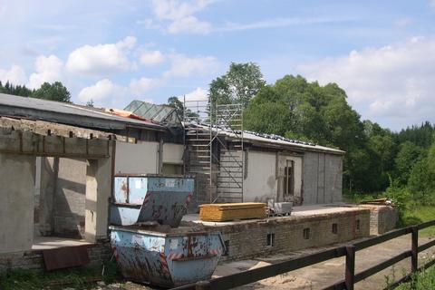 Das letzte alte Oberlichtfenster wird abgebrochen, während von der rückseitigen Giebelwand schon an der Dacheindeckung gearbeitet wird.