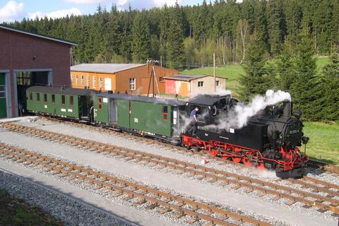 An der Fahrzeughalle rangiert 99 1715 mit einem Zug.