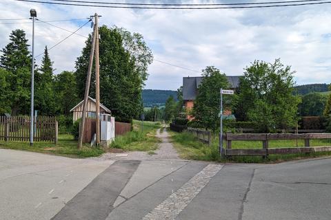 In der Kreuzung mit dem Wiesenweg wurden die Telekommunikationsleitungen in den Erdboden verlegt (linker Asphaltstreifen).