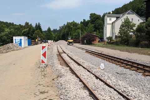 Mit dem Bagger wurde der Schotter ins Gleis gekippt.