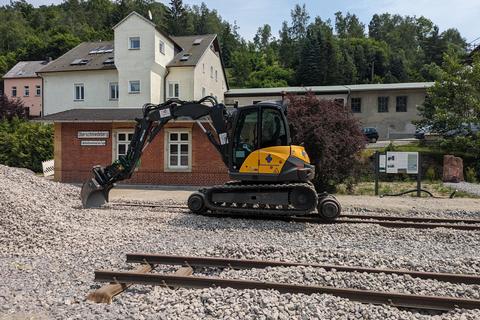 Bagger am Schotterhaufen vor dem Empfangsgebäude in Oberschmiedeberg.