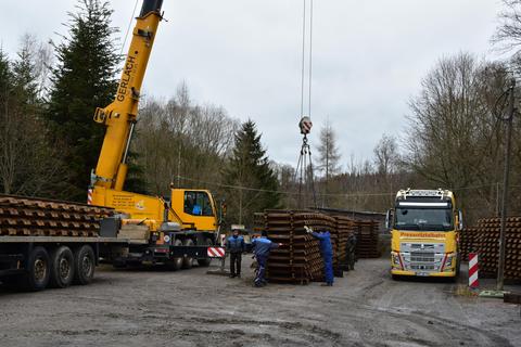 Im Bereich nahe des Stationsgebäudes werden die cirka 15 Meter langen Gleisjoche auf Stapel vom Lkw abgeladen.