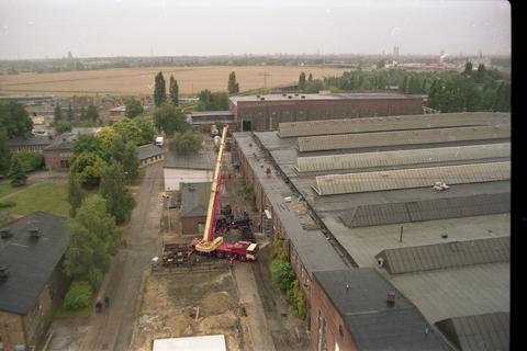 13.08.1992. Im dritten Schritt geht es für die Lok jetzt direkt auf den bereitstehenden Schmalspurbahntransportwagen. Der Blick vom Wasserturm des Leipziger Ausbesserungswerkes läßt in der Ferne das Leipziger Universitätshochhaus erkennen. Foto: Sammlung Jörg Müller